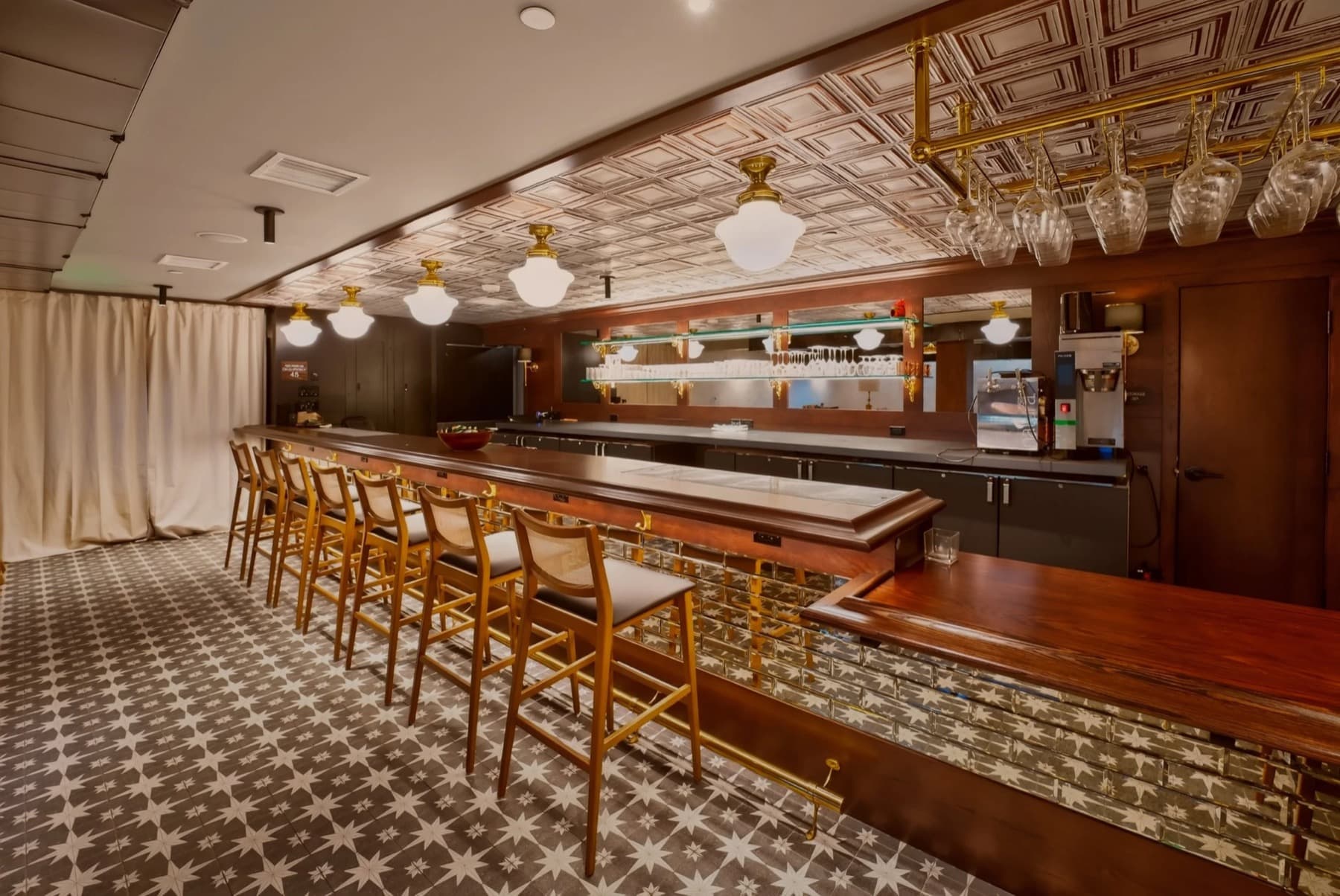 The bar at The Grove, lined with brass fixtures and hanging glassware